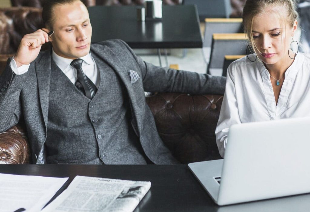 two-businesspeople-working-laptop-caf two-businesspeople-working-laptop-caf